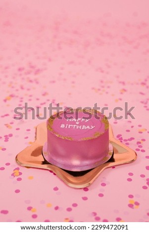 Trendy pink birthday bento cake on a golden plate in the shape of a star on a pink background with confetti
