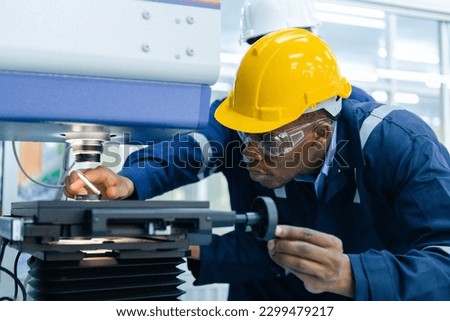 Specialist male African American engineer workers in manufacturing factory workplace. Microchip testing staff Operations of robots in industrial plants. Trade and research parts, modern production.