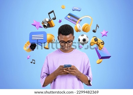 Smiling black man play video games, typing in phone, diverse digital world icons on blue background. Concept of social media, entertainment and online shopping Royalty-Free Stock Photo #2299482369