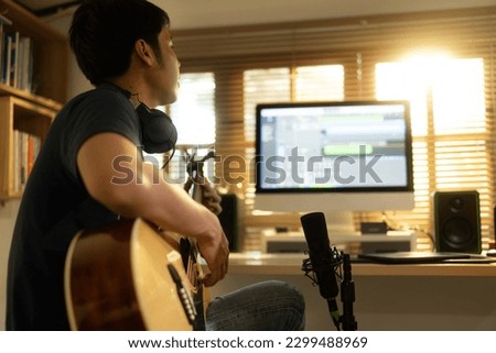 Asian man making music at home studio