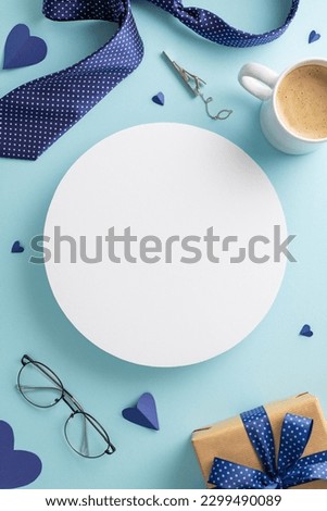 Show your appreciation for Dad on Father's Day by showcasing a coffee, tie, spectacles, giftbox, and accessories on a blue background with an empty circle for text or advert. Top view vertical picture