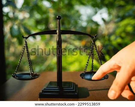 Tip the scales of justice concept as a the hand of a person illegally influencing the legal system for an unfair advantage.	
 Royalty-Free Stock Photo #2299513859