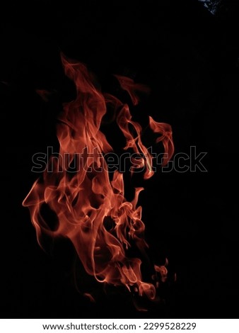 This is a picture of a flame, which appears to be burning brightly with intense heat. The flame is orange and yellow in color, with a long, thin shape that tapers at the top. It appears to be dancing 