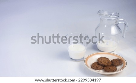 Background concept for world milk day,  picture a jug of milk, glass  and chocolate 
chip cookies on the table,  isolated in white background, copy space.