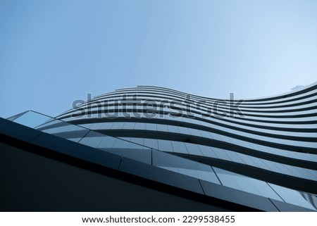 A modern building with interesting architectural curves in Novi Sad Serbia. Picture taken on a bright blue sky day. Shadows falling perfectly on the building Royalty-Free Stock Photo #2299538455