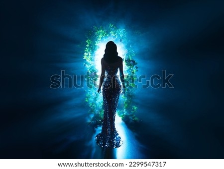 dark shadow silhouette fantasy woman walking in black night garden in fog glowing portal arch flowers, art neon blue magic light. Mystery lady. Gothic luxury Girl princess shiny dress back rear view Royalty-Free Stock Photo #2299547317
