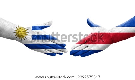Handshake between Costa Rica and Uruguay flags painted on hands, isolated transparent image.
