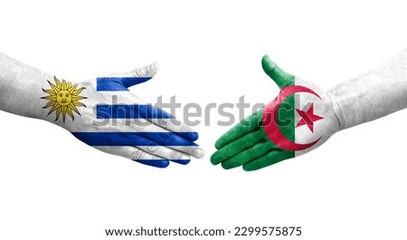 Handshake between Algeria and Uruguay flags painted on hands, isolated transparent image.