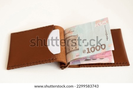 Ukrainian hryvnia money in leather money clip, wallet. Ukraine money on white background with. Currency of Ukraine. Accessories. Money, financess, economy, saving.