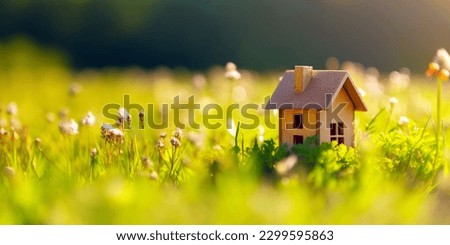 Green and environmentally friendly housing concept. Miniature wooden house in spring grass, moss and ferns on a sunny day. Eco house Royalty-Free Stock Photo #2299595863