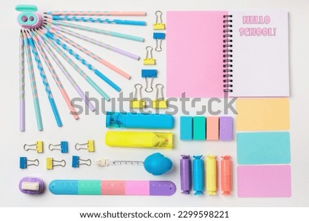 Flatlay, stationery. Colourful stationery in pastel colours, on a white background, with the words Hello School!  Back to school concept.