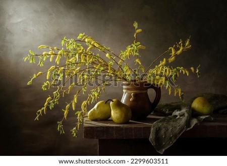 Still life with spring willow branches in an earthenware jug and pears on a dark background.