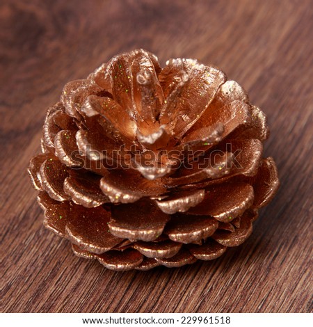 golden pine cone over wooden background on Holiday theme/Christmas Decoration Over Wooden Background