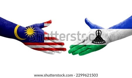 Handshake between Lesotho and Malaysia flags painted on hands, isolated transparent image.