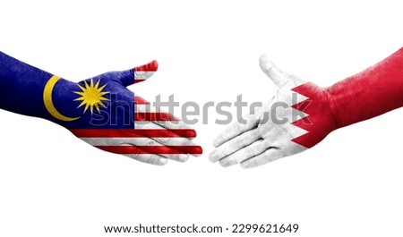 Handshake between Bahrain and Malaysia flags painted on hands, isolated transparent image.