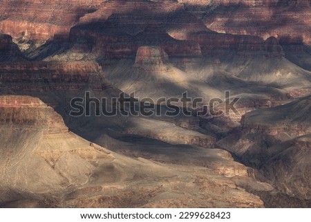 Discover the geological wonder of the Grand Canyon's layers as sunlight illuminates its breathtaking depth and colors. Royalty-Free Stock Photo #2299628423