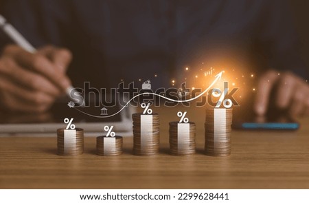 interest rates and dividends, investment returns, income, retirement Compensation fund, investment, dividend tax. pile of coins and upward direction percentage symbol. saving money for investment Royalty-Free Stock Photo #2299628441