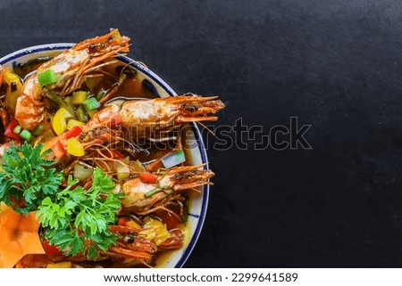 Salt fried shrimp with sauce and vegetables isolated on black backround