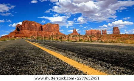 Scenic drive through Monument Valley Road, iconic red sandstone formations, and vast desert landscape.