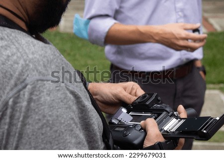 Photographer changing the roll of his analog camera Royalty-Free Stock Photo #2299679031