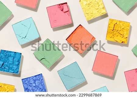Cosmetic beauty product multicolor eyeshadows for makeup on beige colored background, color pallete swatches powder eyes, top view, flat lay pattern, Female cosmetic beauty product, shiny eye shadow  Royalty-Free Stock Photo #2299687869