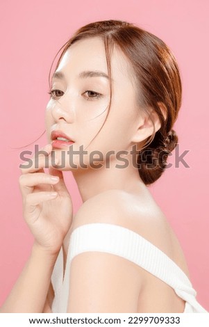 Young Asian beauty woman pulled back hair with korean makeup style touch her face and perfect skin on isolated pink background. Facial treatment, Cosmetology, plastic surgery. Royalty-Free Stock Photo #2299709333