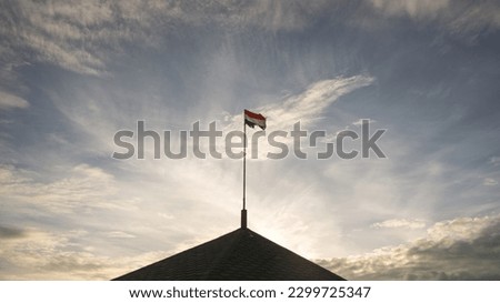waving torn Hungarian flag in the sky
