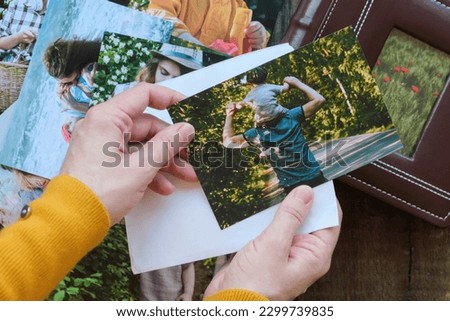 Person looks at printed photos for family photo album. Overhead shot.