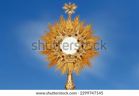 Monstrance for adoration in a Catholic church ceremony - Adoration of the Blessed Sacrament - religious symbol on blue background Royalty-Free Stock Photo #2299747145