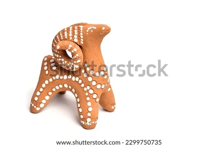 Clay toy souvenir ram on a white background. Ethno clay product handmade. Royalty-Free Stock Photo #2299750735