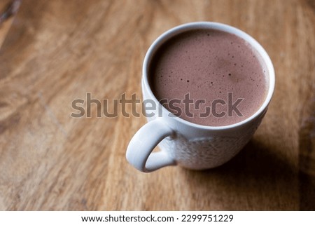 A cup of cocoa, hot chocolate, a warm comforting beverage made from cocoa powder, sugar, and milk or cream that creates rich and creamy drink. Winter and holiday-themed dessert or comforting treat.