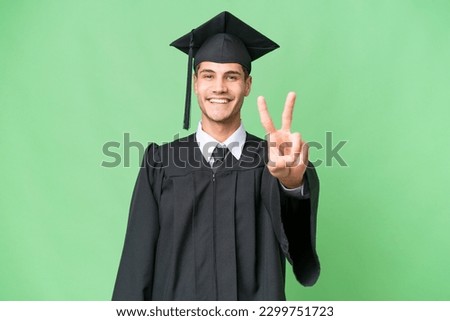 Young university graduate caucasian man over isolated background smiling and showing victory sign