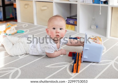 Tummy time of a cute caucasian baby. Playing child. Baby portrait Royalty-Free Stock Photo #2299753053