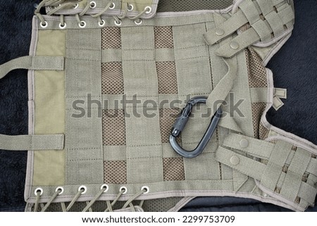 Carbine, carabine, spring hook, shackle, clevis, dragon Camouflage background. Military uniform. War wallpaper. Disguise. Protection. Khaki. Soldier textiles. Texture of the spots. Camouflage colors