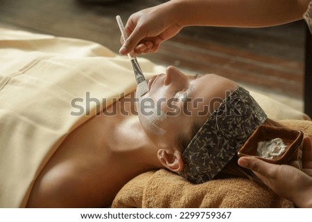 Young woman at natural beauty spa having facial treatment. Relaxation, detoxification, exfoliation of skin rejuvenation concept.	 Royalty-Free Stock Photo #2299759367