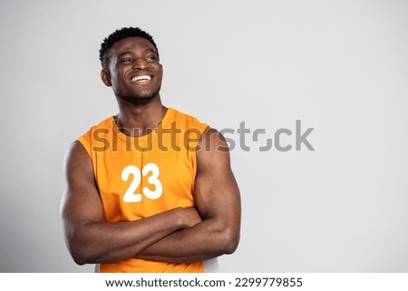 Portrait of handsome muscular African man, smiling basketball player with arms crossed looking away, isolated on white background, copy space. Sport concept  