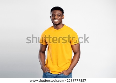wearing orange t shirt isolated on white background. Happy  stylish Nigerian student looking at camera, education concept 