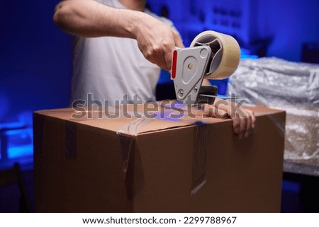 young man packing a monitor in a cardboard box Royalty-Free Stock Photo #2299788967