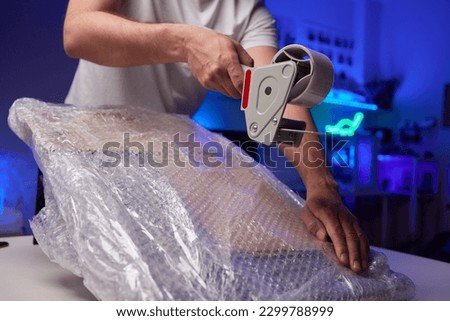 young man packing a monitor in a cardboard box Royalty-Free Stock Photo #2299788999