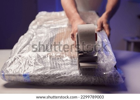 young man packing a monitor in a cardboard box Royalty-Free Stock Photo #2299789003