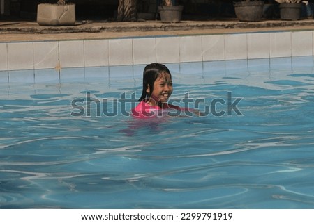jakarta,indonesia-october 2022:little kids playing in the water and learning to swim