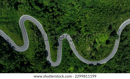 aerial top view drone shot ROAD No.1081 or shape number three of winding mountain road between Pua District, Nan Province, Thailand is highlight point and landmark that tourist like to take pictures 
