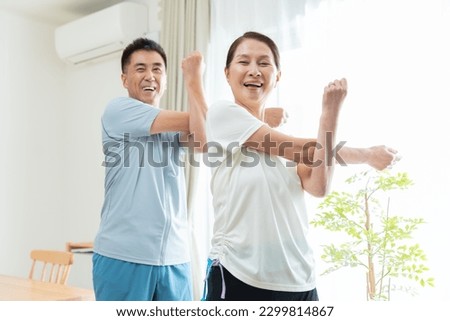 Japanese couple wearing sportswear in the living room Royalty-Free Stock Photo #2299814867