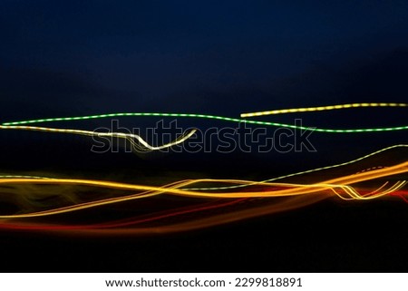 Red, green, and yellow bolts of light stretching horizontally