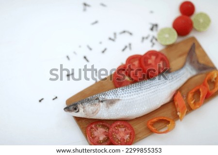 Buri, one fish on a white table, sliced ​​tomatoes, chili pepper, healthy food, very useful product, contains protein, easily digestible, omega-3 fatty acids, method of preparation, background, photo,