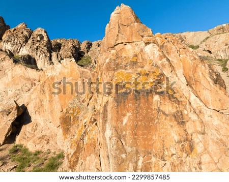 Tamgaly-Tas (Painted Rocks or Stones with Signs) with rock paintings of Tibetan iconography and inscriptions dated to the second half of the 17th century. Royalty-Free Stock Photo #2299857485