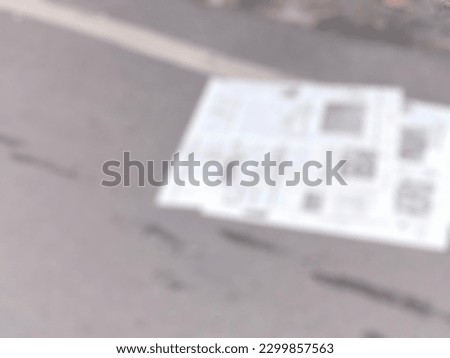 defocused photo of a newspaper lying on the street