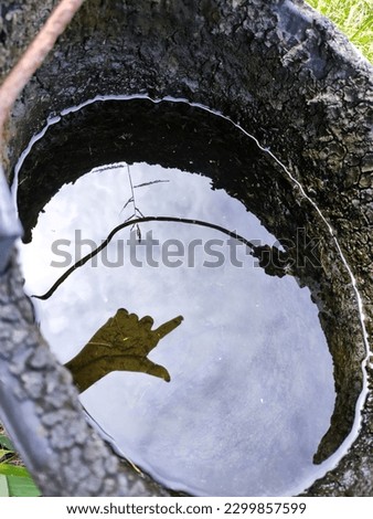 Hand shadow in water in bucket