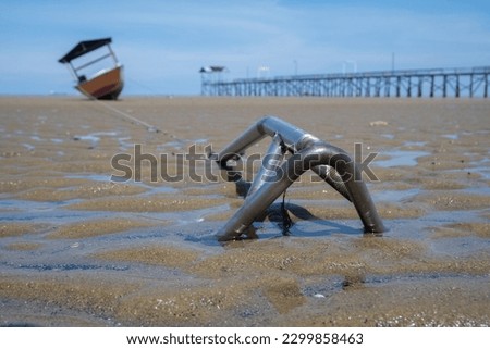 selective focus on fishing boat anchors attached to beach sand