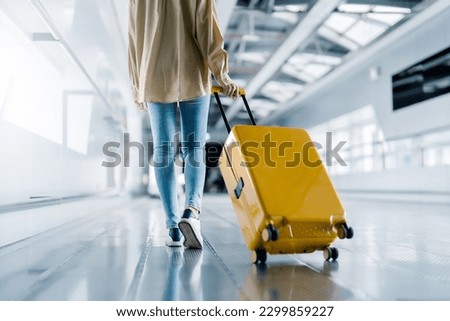 International airport terminal. Asian beautiful woman with luggage and walking in airport Royalty-Free Stock Photo #2299859227